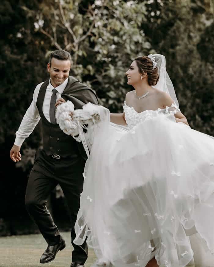 services-03 Smiling couple enjoys a dance on their wedding day, capturing romance and elegance amidst natural surroundings.