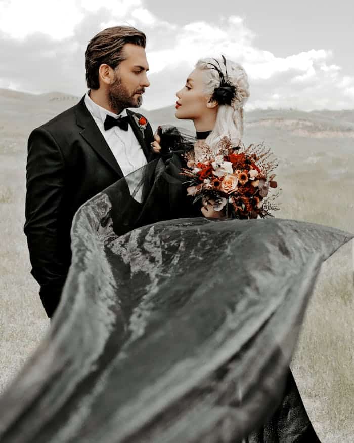 services-04 Outdoor wedding photo of a couple in elegant attire with a black gown and bouquet.